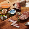 Hand-painted wooden play food pieces including bacon, sausage and tuna in tray-style packaging