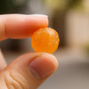 Individually wrapped sugar-free sour orange hard candies by Andy Anand spread out on a surface