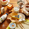 Close-up of wooden pretend play dairy food pieces with whimsical food labels and non-toxic paint finish
