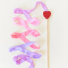 Decorative ribbon with a heart on a stick against a light background