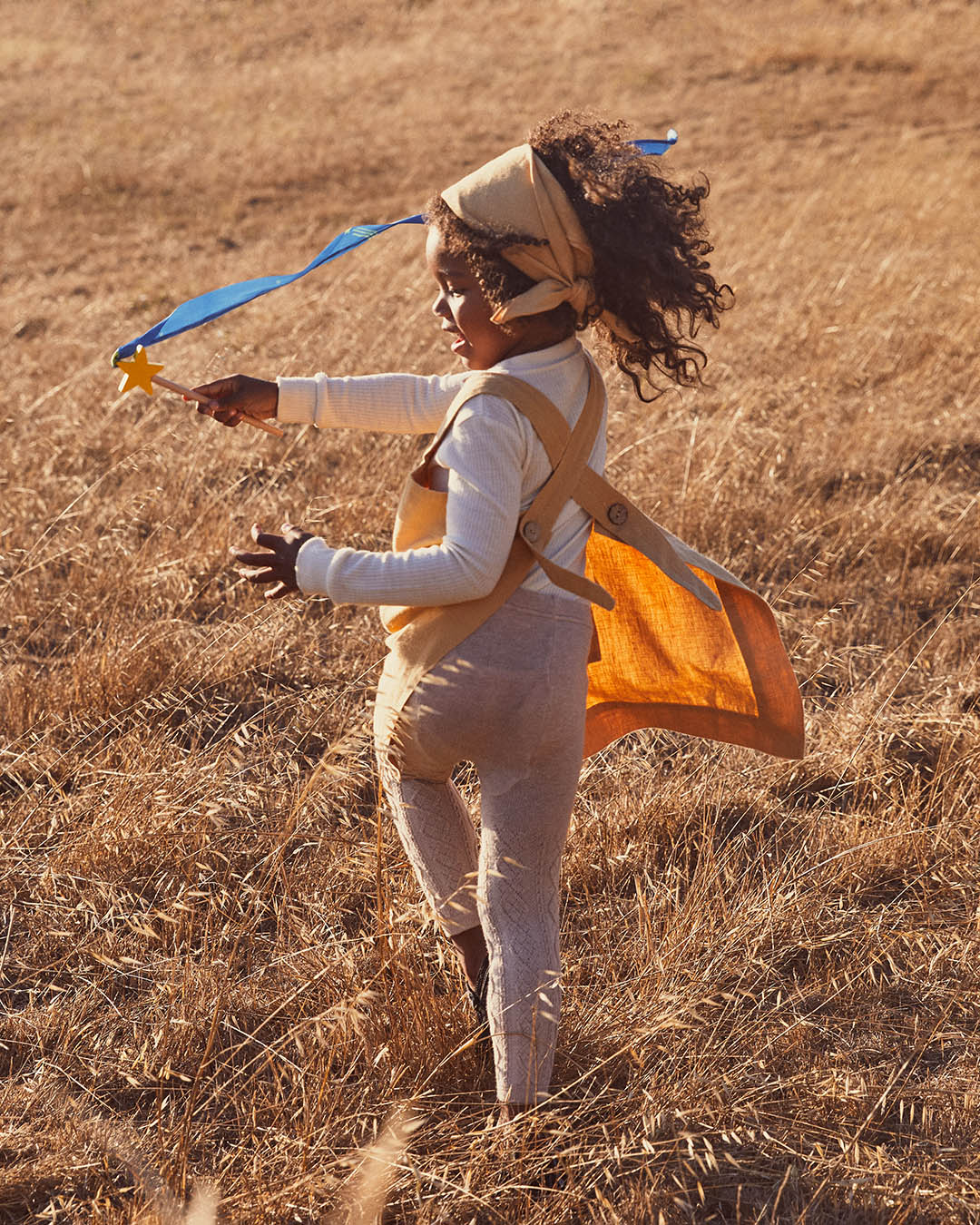 Person in a costume with wings running through a field