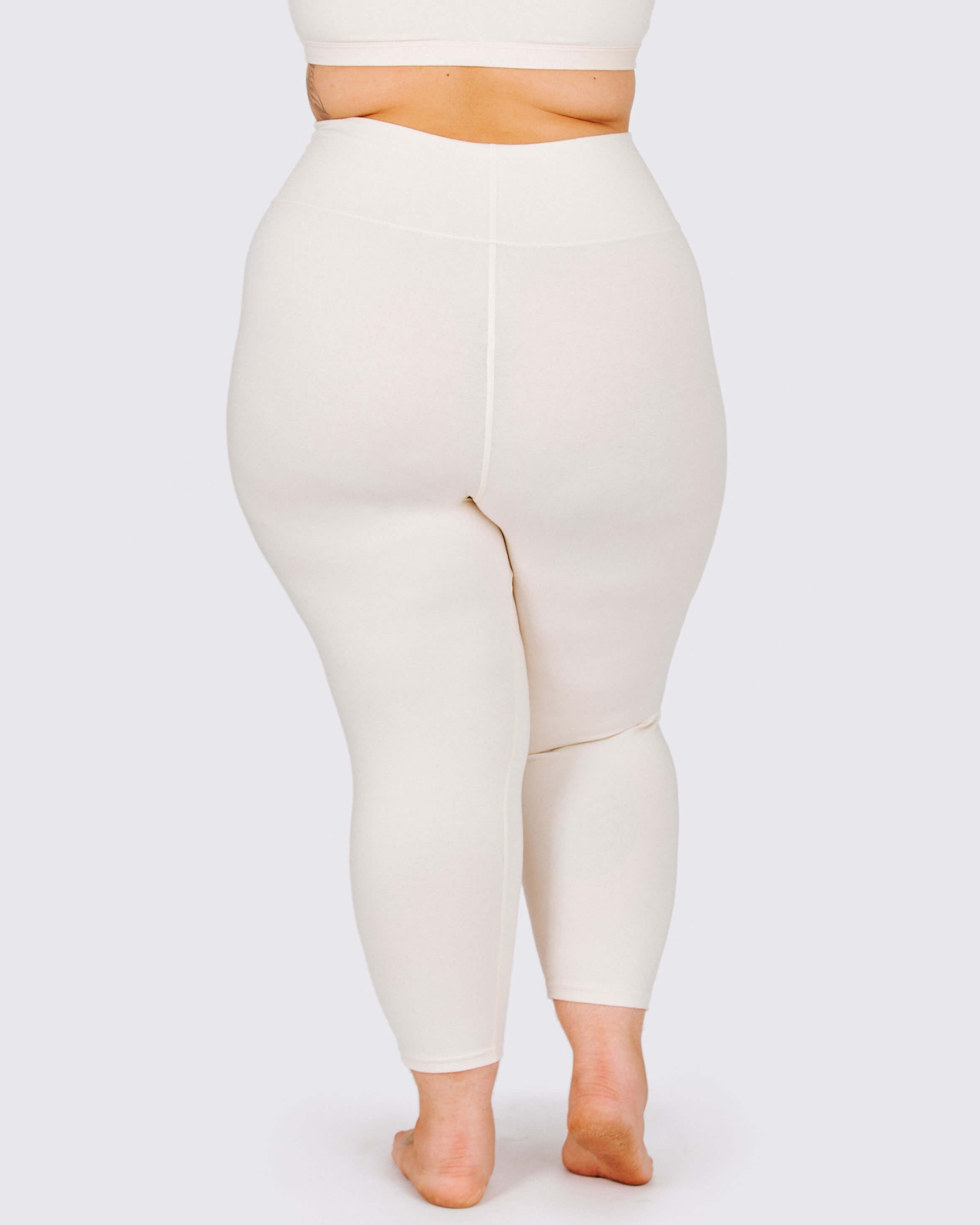 Person wearing a pair of beige leggings on a white background