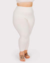 Person wearing white leggings on a plain background
