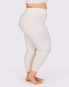 Person wearing cream leggings on a white background