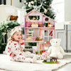 Child playing with a dollhouse and teddy bear in a cozy room with Christmas decorations.