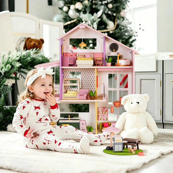 Child playing with a dollhouse and teddy bear in a cozy room with Christmas decorations.