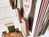 Wooden record holder with vinyl records and a photo album on a white surface.