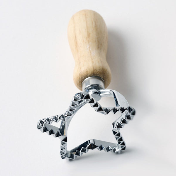 Metal star-shaped cookie cutter with wooden handle on a white background