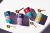 Colorful tins with wooden spoons on a white background