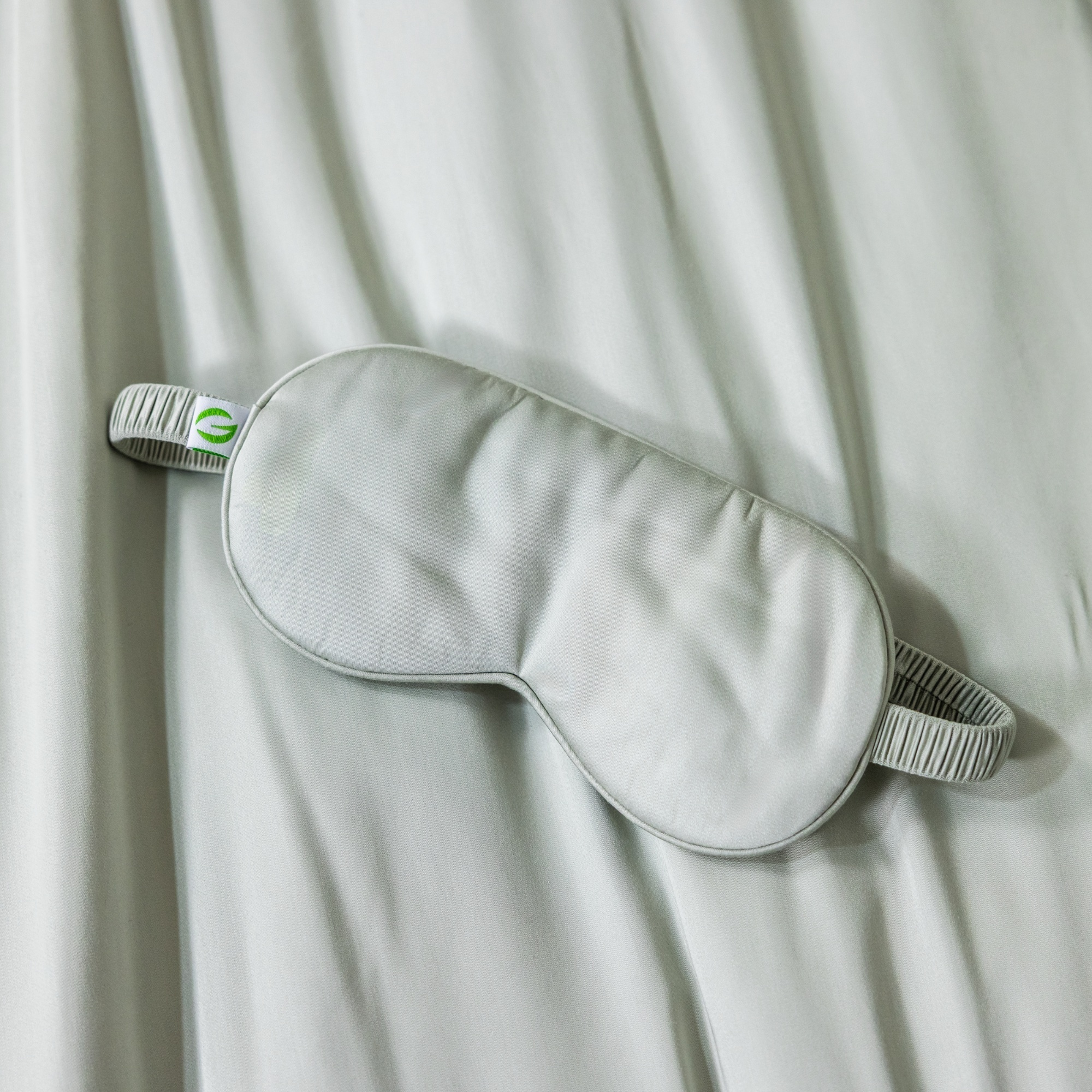 Gray sleep mask on a white fabric background