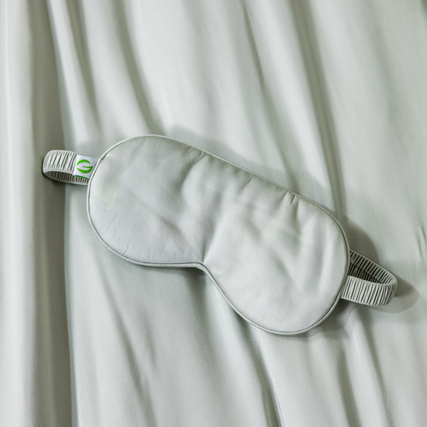 Gray sleep mask on a white fabric background