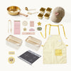 Collection of kitchen items including a pan, apron, and various kitchen accessories on a white background
