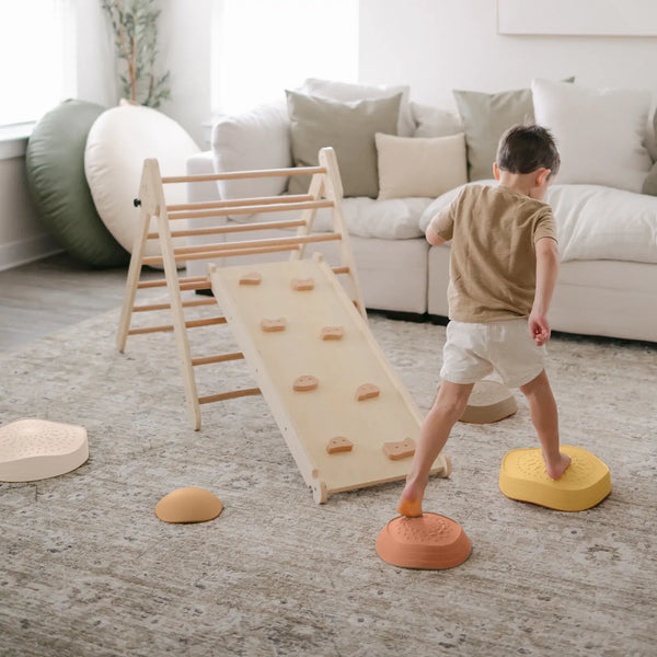 Child playing with colorful stepping stones in a living room setting