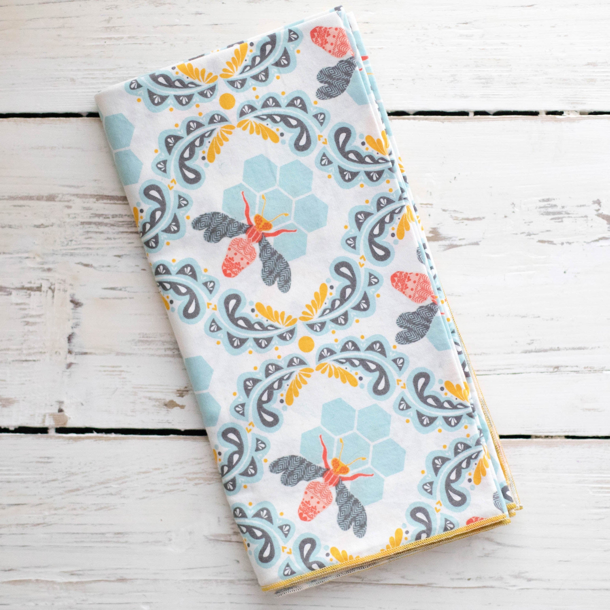Flat lay of all four honey bee cotton napkins in dinner, everyday, and cocktail sizes