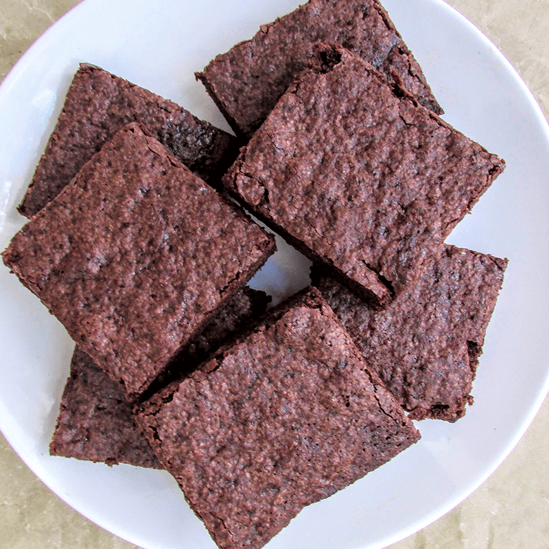 Square pieces of brownies on a white plate