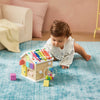 Baby playing with a colorful wooden toy on a blue carpet