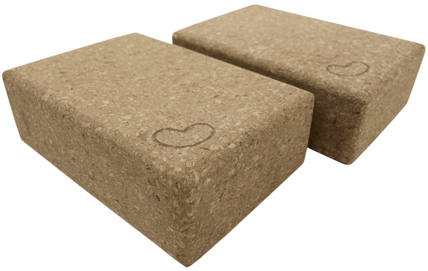 Two brown yoga blocks with heart designs on a white background