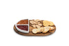 Wooden charcuterie board with crackers and dips on a white background