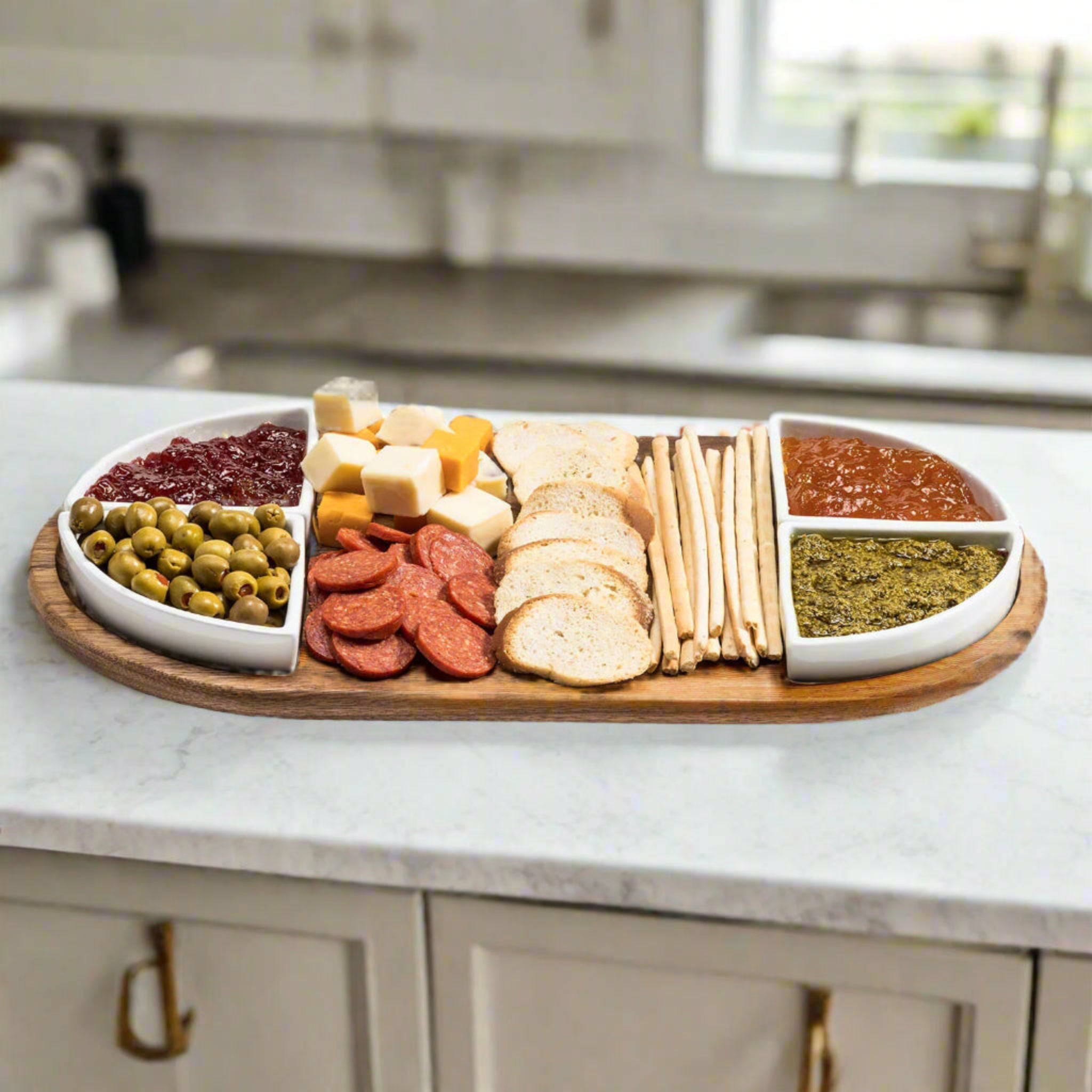 Wooden charcuterie board with various food items on a kitchen counter