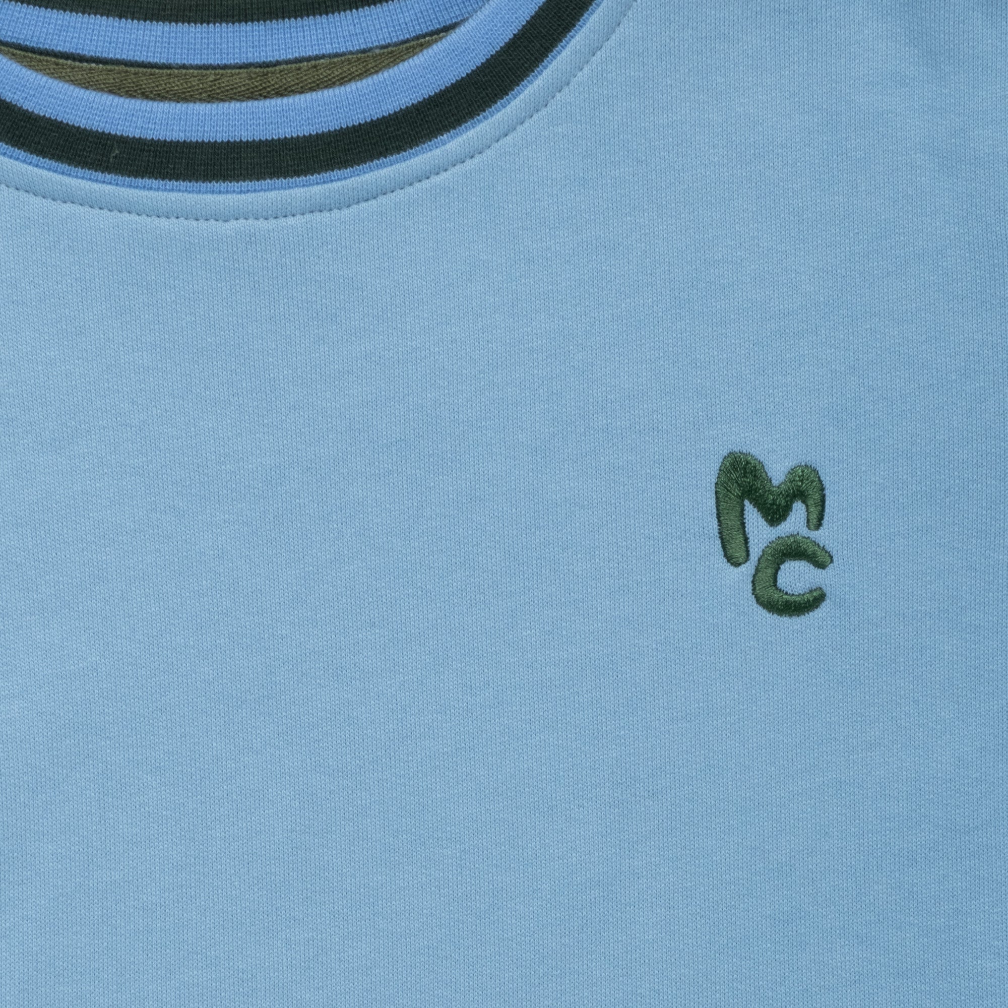 Close-up of Mon Coeur MC Blue Sweatshirt showing ribbed cuff and logo detail