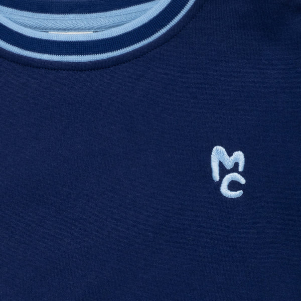 Close-up of Mon Coeur Kids MC Navy Sweatshirt showing signature MC logo and rib trim detail