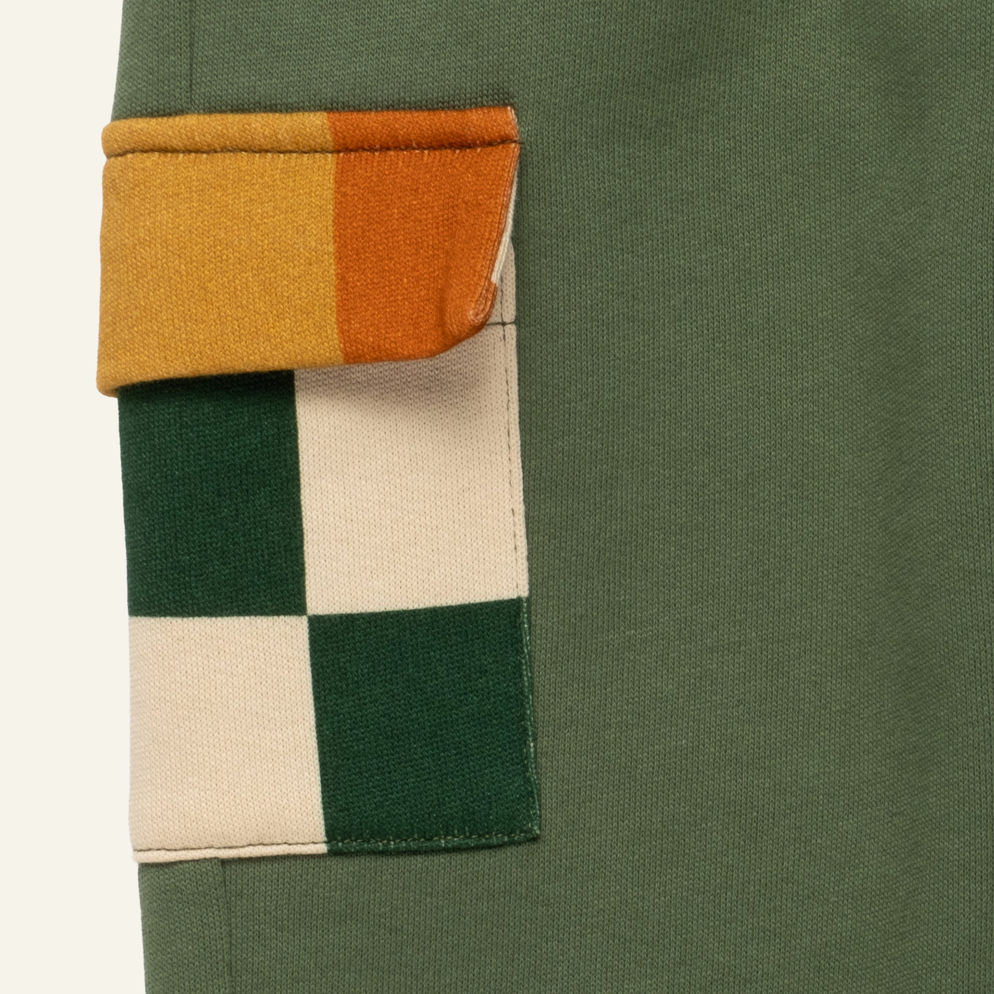 Close-up detail of the contrast checkered pocket on the Mon Coeur Green Pocket Jogger