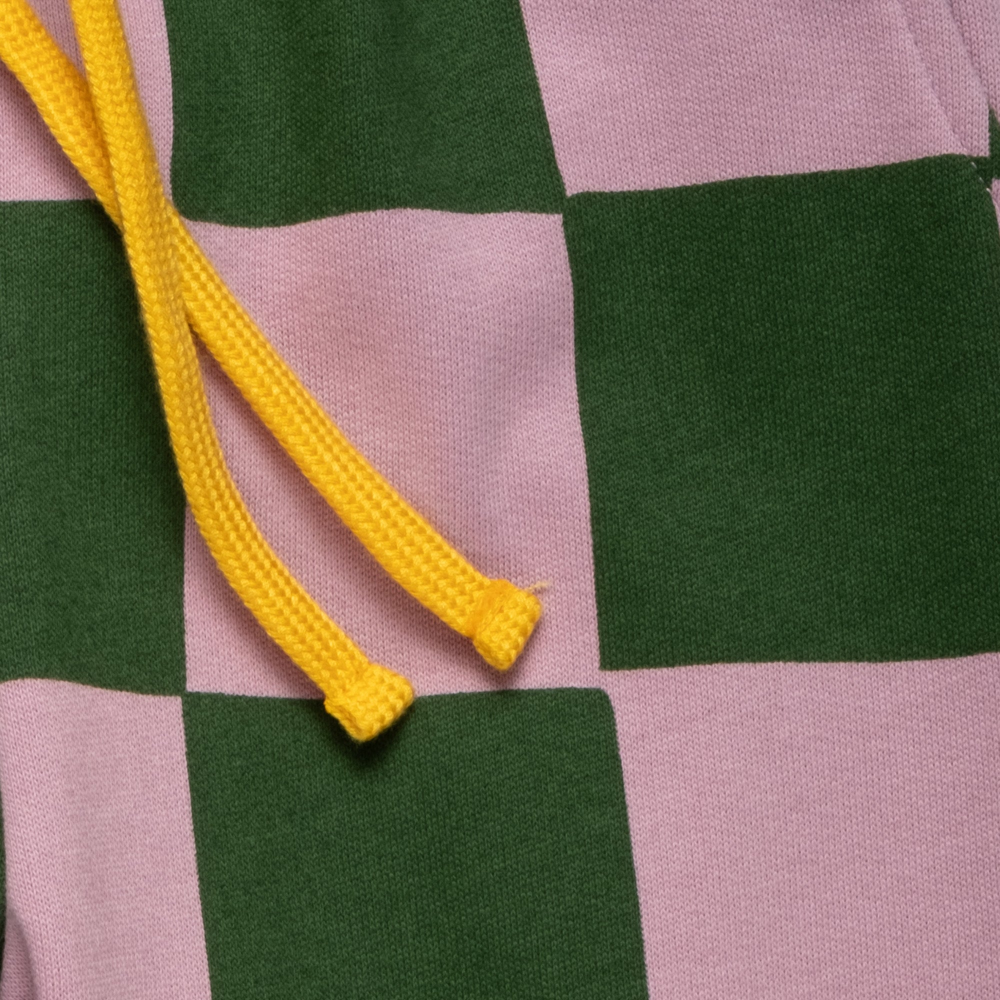 Close-up of the Mon Coeur Kids Green Checkered Jogger showing the bold checkerboard print and tapered fit