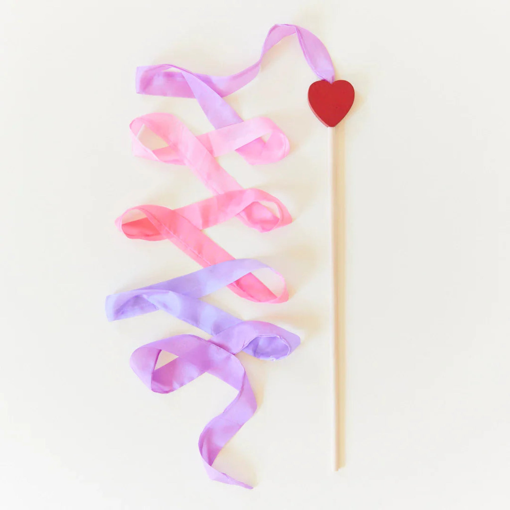 Decorative ribbon with a heart on a stick against a light background
