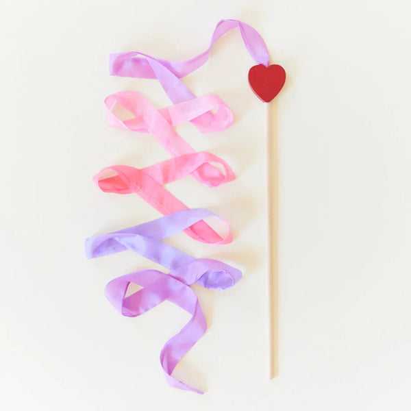 Decorative ribbon with a heart on a stick against a light background