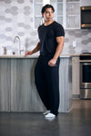 Man in black outfit standing in a modern kitchen