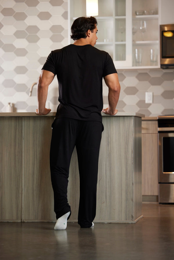 Man standing in a modern kitchen with geometric tile backsplash