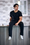 Man sitting on a kitchen counter wearing black clothing.