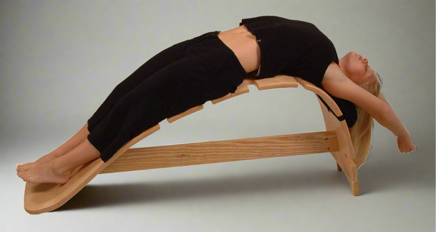 Person using The Whale back stretching bench for a supported backbend and spine stretch