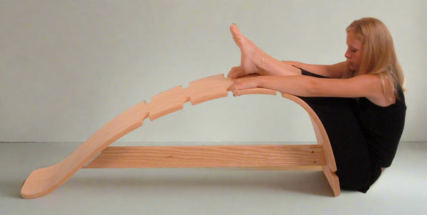 The Whale therapeutic back stretching bench displayed in a home wellness or yoga studio setting