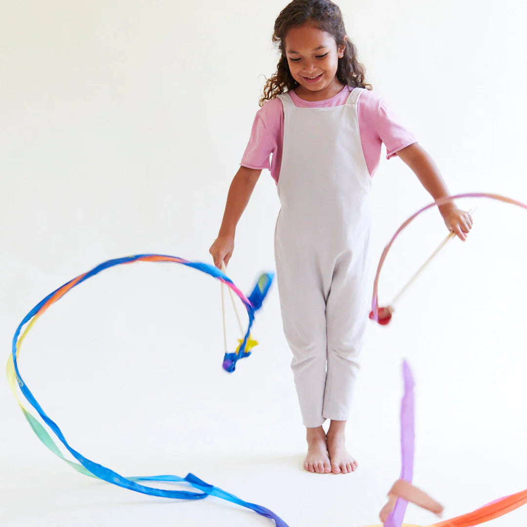 Child playing with colorful hula hoops on a white background