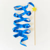 Blue ribbon on a wooden stick with a yellow star against a white background