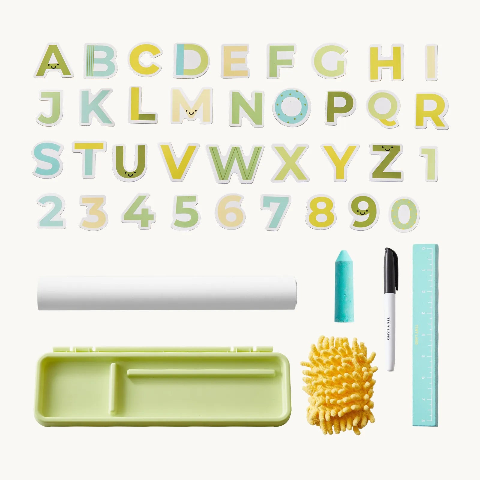 A children's alphabet and number learning set arranged on a light cream background, including pastel alphabet letters, numbers 0-9, a white roll, a light green tray, a turquoise marker, a black-and-white paintbrush, and a yellow sponge.