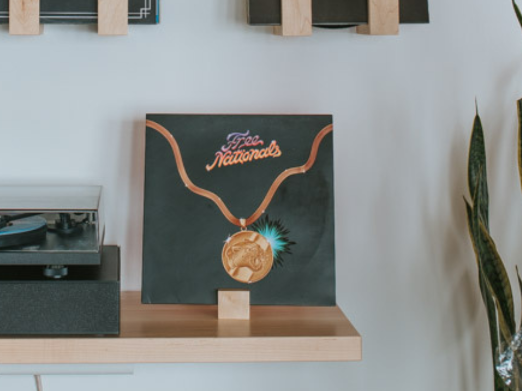 Canvas print of a necklace with 'The Nationals' text on a stand against a white wall.