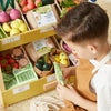 Child playing with toy groceries in a store setting