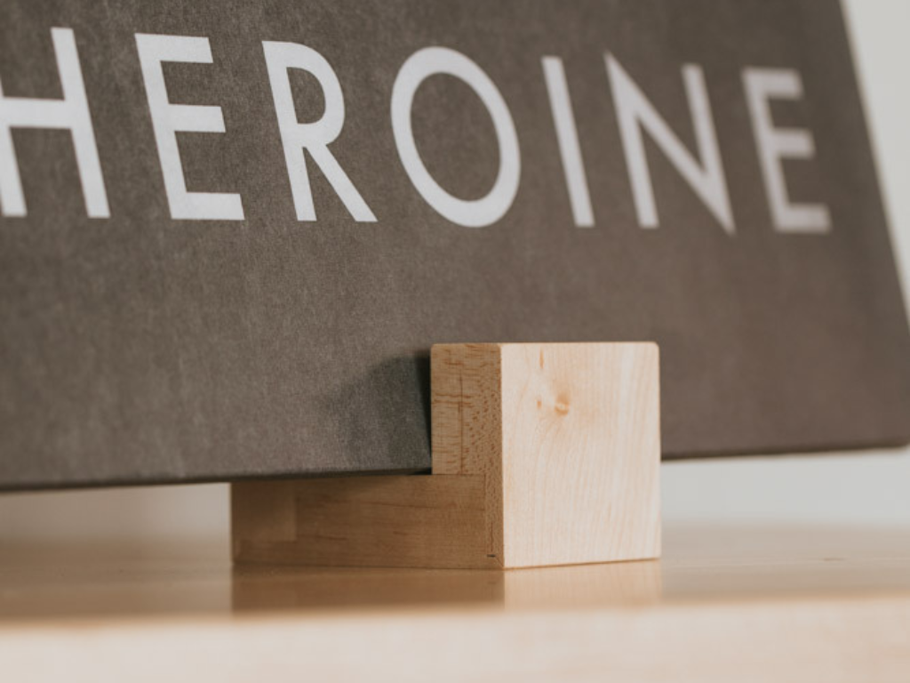 Wooden blocks with a sign reading 'HEROINE' in the background