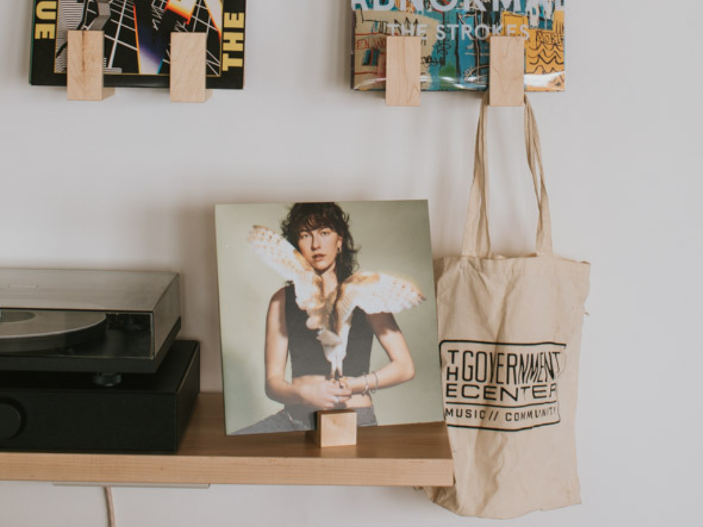 Tote bag with 'The Government Center Music & Coffee' logo next to a vinyl record player and album cover.