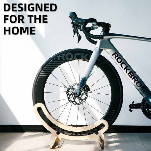 Bicycle on a stand with 'Rockbro' branding against a light background. ROCKBROS wooden bike stand — tool-free 2-min assembly, fits most road bikes, eco-friendly natural wood. Stable, portable & stylish. Perfect cyclist gift. Shop now.