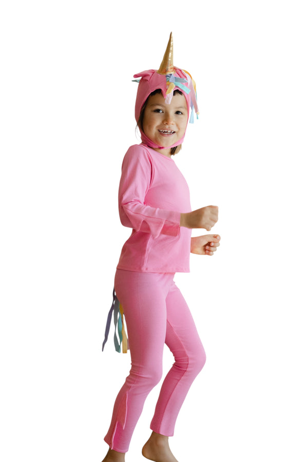 Child wearing a pink unicorn costume on a white background