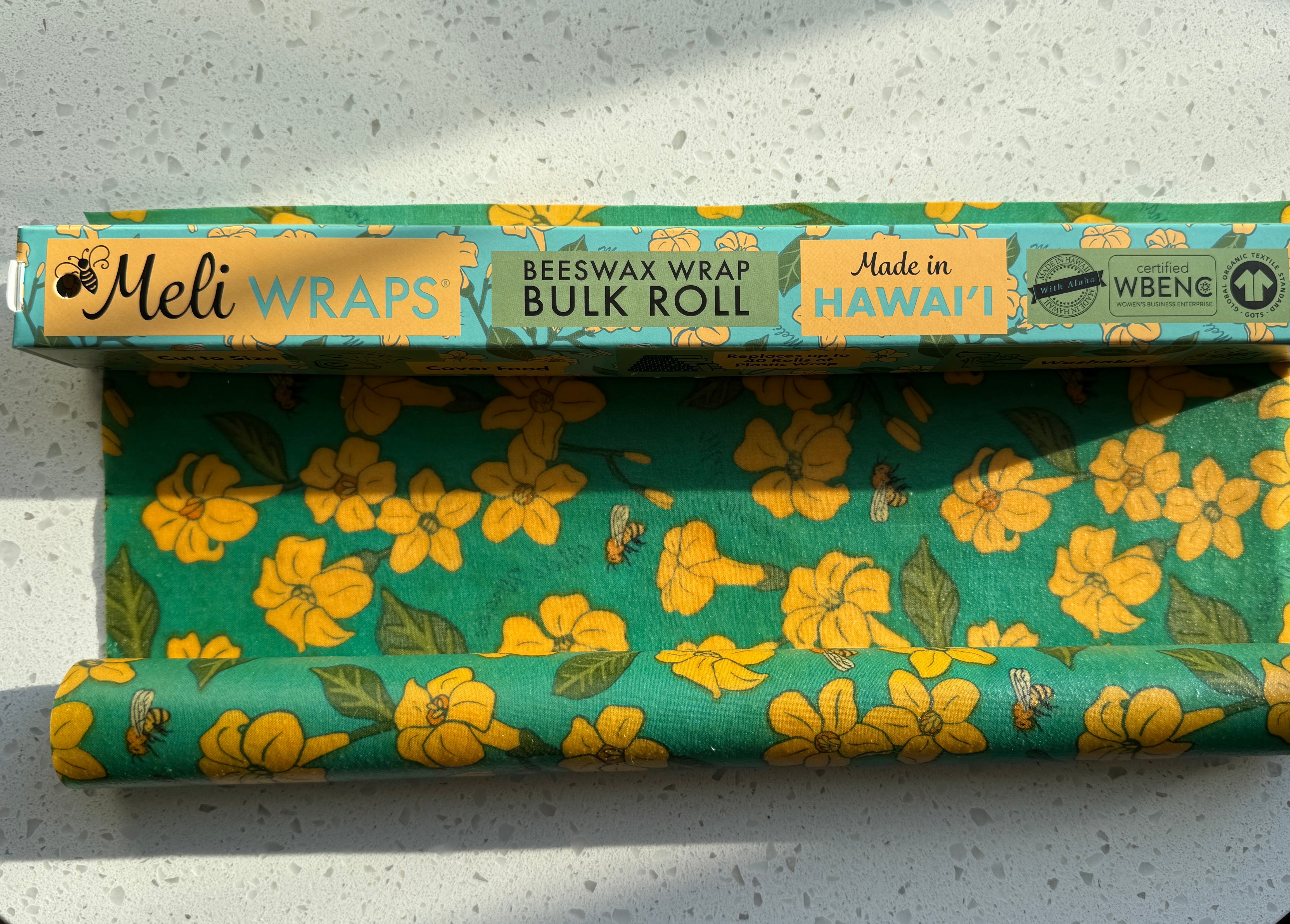 Puakenikeni & Bee print beeswax wrap covering a dish