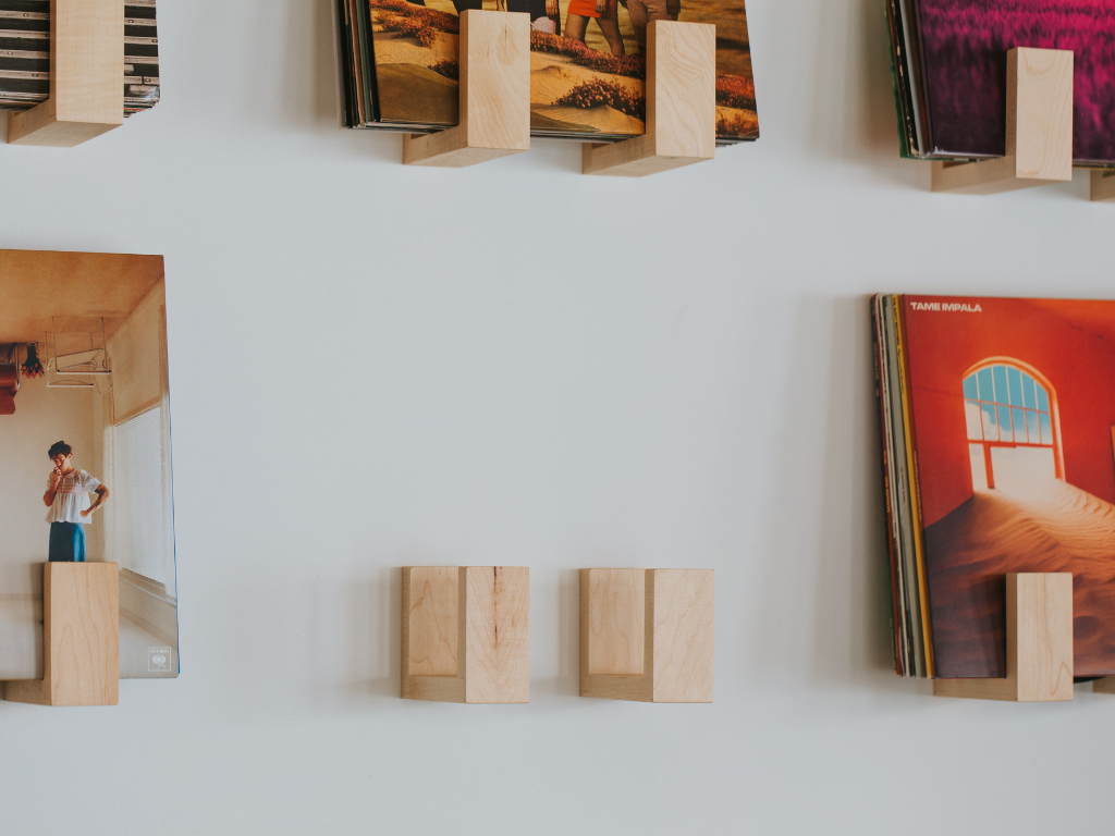 Wooden bookends holding books against a white wall