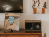 Wooden speaker on a shelf with framed artwork in a room setting
