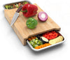 Wooden cutting board with knife and vegetables on a white background