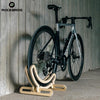 Bicycle on a wooden stand against a wooden wall with 'RockBros' branding.