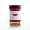 Jar of hot honey with a label featuring a red chili pepper on a white background. Spice up your meals with Organic Hot Honey – fair-trade, unpasteurized forest honey infused with Ontario chili peppers. Sweet, spicy, and sustainable. Perfect on pizza, cheese, or ice cream. Shop now!