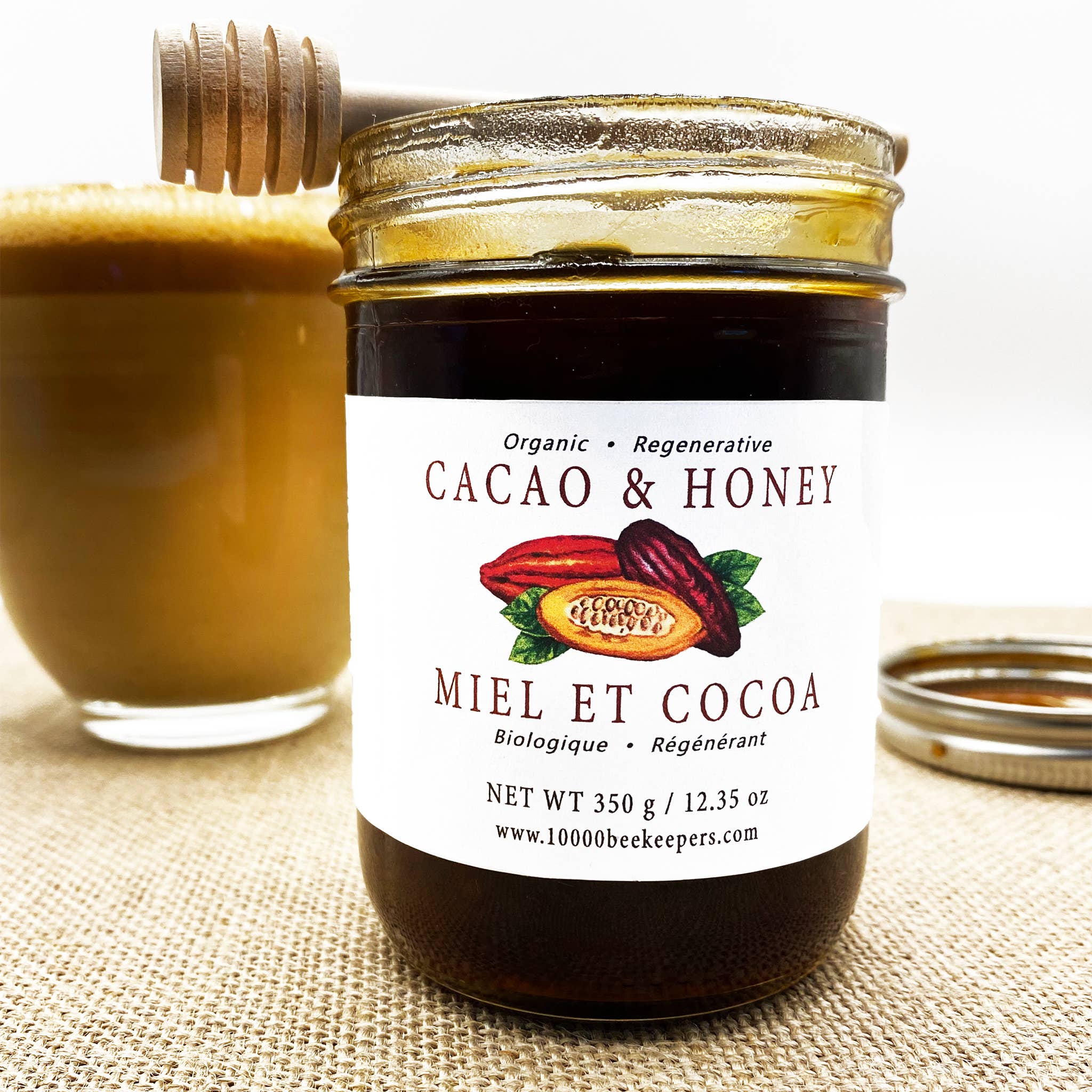 Jar of Cacao & Honey with a glass of honey on a textured surface